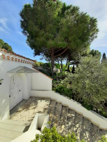 a white garage with a tree in the background at Villa Rasoa in Cap d'Agde