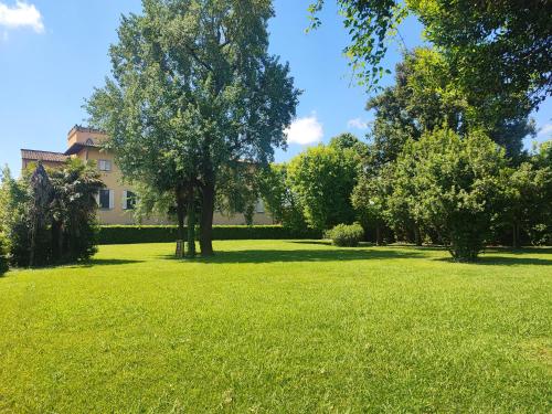 a field of green grass with a house in the background at Appartamento in Villa Aulla in Pontedera