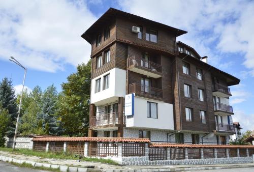a brown and white building on the side of a street at Apartments & Studios Mountain Romance in Bansko