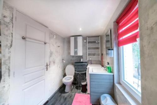 a bathroom with a toilet and a sink and a window at Studio Moovy Proche Stade Groupama, LCLD ARENA , Eurexpo Lyon in Meyzieu