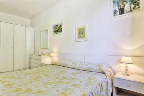 a white bedroom with a bed and two night stands at Casa Helba - Colle Paradiso Experience in Capoliveri