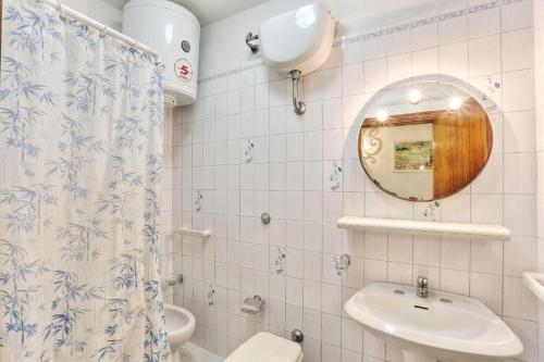 a bathroom with a sink and a toilet and a mirror at Casa Helba - Colle Paradiso Experience in Capoliveri