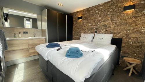 a bedroom with a large bed with blue towels on it at Poellodge, Luxe houseboot met zonnig terras in Aalsmeer