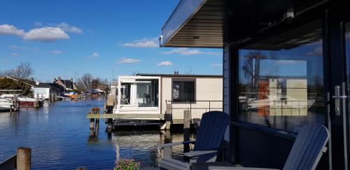 a house sitting on a dock on a body of water at Poellodge, Luxe houseboot met zonnig terras in Aalsmeer