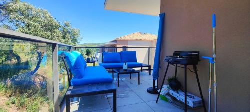 un balcon avec deux chaises bleues et une caméra dans l'établissement Spacious apartment with lovely terrace, à Saint-Raphaël