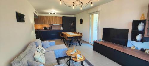 un salon avec un canapé et une télévision dans l'établissement Spacious apartment with lovely terrace, à Saint-Raphaël