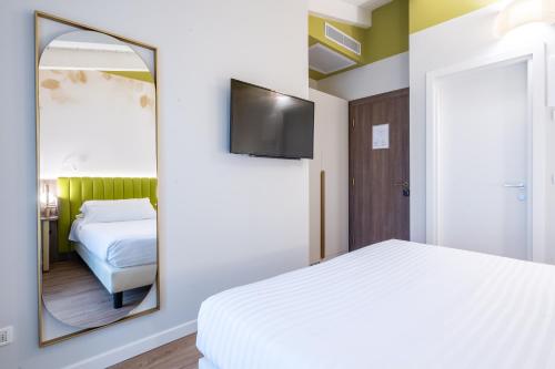 a bedroom with a mirror and a bed at Hotel Regina Elena 57 & Oro Bianco SPA in Rimini
