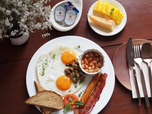 a breakfast plate with eggs sausage beans and toast at Blu Monkey Boutique Phuket Town in Phuket Town