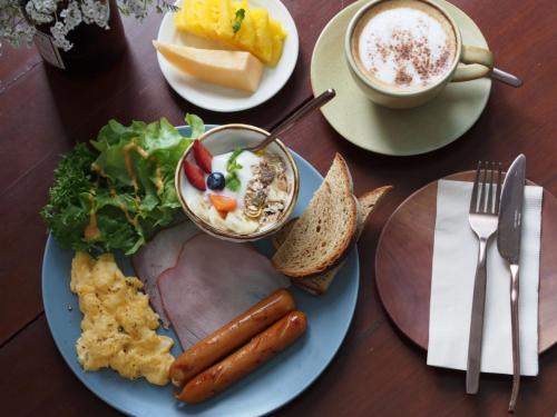 a table with a plate of food and a cup of coffee at Blu Monkey Boutique Phuket Town in Phuket Town