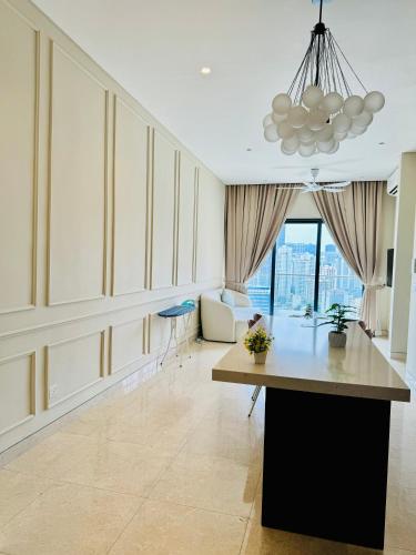 a living room with a table and a chandelier at LUCENTIA RESIDENCE By LALAPORT in Kuala Lumpur