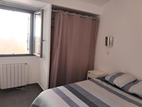 une chambre avec un lit et une fenêtre dans l'établissement Charmante Maison à 15 minutes de la place Comédie, à Montpellier