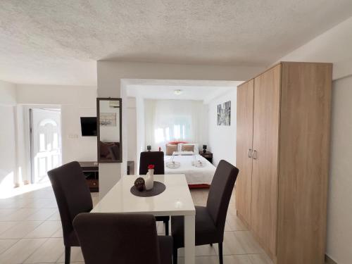 a dining room with a table and chairs and a bed at Apartments Pribilovic in Budva