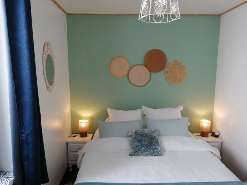una camera con un letto bianco e una parete blu di Le Coty a Fécamp