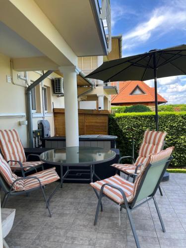 a patio with two chairs and a table and an umbrella at Panoráma Villa in Balatonboglár