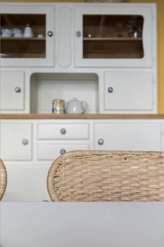 a kitchen with white cabinets and a table with a basket at Oasi di pace vista lago-Cardada-Locarno in Orselina