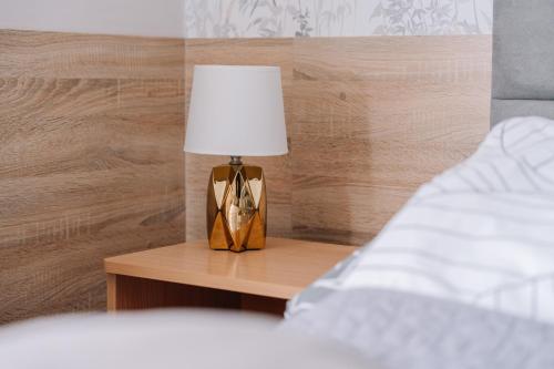 a lamp sitting on a table next to a bed at DW Turysta in Licheń Stary