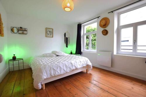 1 dormitorio con 1 cama, 2 ventanas y suelo de madera en Le Notre Dame, en Ardres