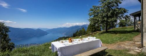 a table on a hill with a view of a lake at Oasi di pace vista lago-Cardada-Locarno in Orselina