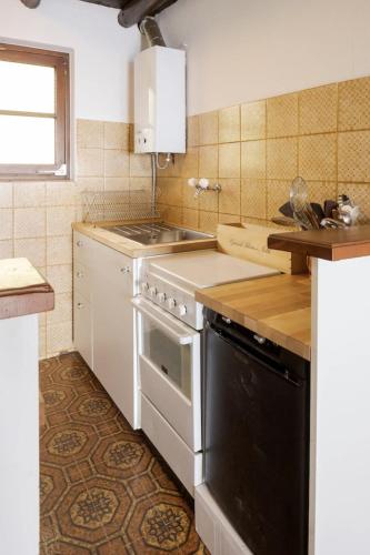 a kitchen with a white stove and a sink at Oasi di pace vista lago-Cardada-Locarno in Orselina