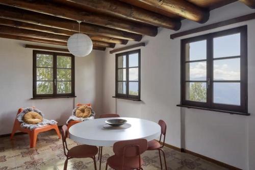 a dining room with a white table and chairs at Oasi di pace vista lago-Cardada-Locarno in Orselina