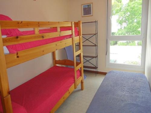 une chambre avec deux lits superposés et une fenêtre dans l'établissement Villa Duplex 3 Pièces, 7 Couchages, Patio Privatif et Parking à La Grande-Motte - FR-1-790-7, à La Grande Motte