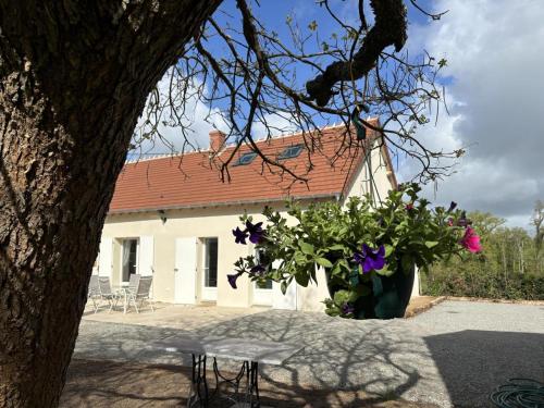 a white house with a red roof and flowers at Charmante maison à Haut-Bocage avec jardin, terrasse, et randonnées à proximité - FR-1-489-516 in La Palisse