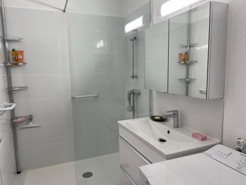 une salle de bain blanche avec une douche et un lavabo dans l'établissement La Grande Motte - 2 pièces avec terrasse, 5 couchages, parking en option - FR-1-790-4, à La Grande Motte