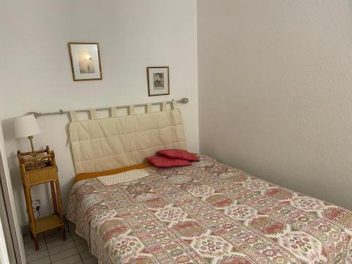 une chambre avec un lit avec un oreiller rouge dessus dans l'établissement La Grande Motte - 2 pièces avec terrasse, 5 couchages, parking en option - FR-1-790-4, à La Grande Motte