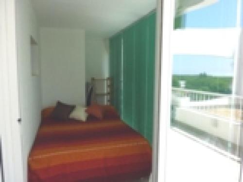 une chambre avec un lit dans une chambre avec une fenêtre dans l'établissement Appartement rénové avec terrasse, piscine, parking, et WIFI - 6 couchages, proche commerces - FR-1-790-19, à La Grande Motte