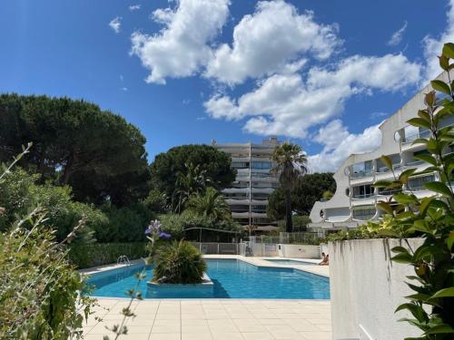 une piscine devant un immeuble dans l'établissement Appartement rénové avec terrasse, piscine, parking, et WIFI - 6 couchages, proche commerces - FR-1-790-19, à La Grande Motte