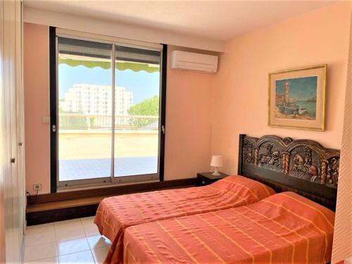 une chambre avec un lit et une grande fenêtre dans l'établissement La Grande-Motte: Appart 3 chambres, terrasse, parking, clim, WIFI - FR-1-790-14, à La Grande Motte