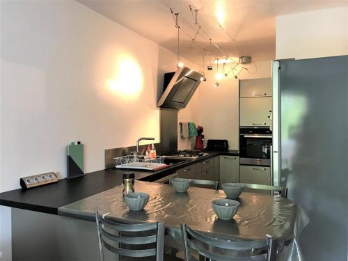 - une cuisine avec une table, des chaises et un évier dans l'établissement Appartement rénové 3 pièces, 6 couchages, proche plage et port, avec loggias et parking à La Grande-Motte - FR-1-790-24, à La Grande Motte