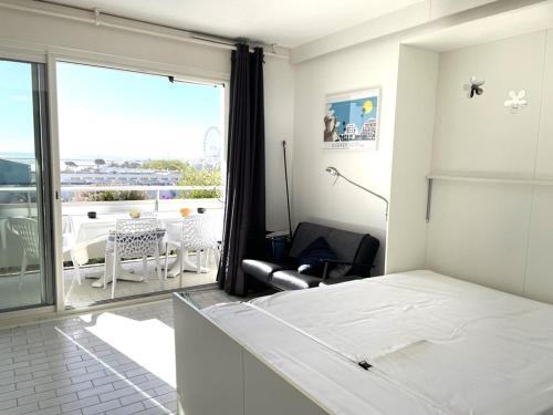 une chambre blanche avec un lit et un balcon dans l'établissement Studio cabine climatisé proche plage avec parking à La Grande Motte - FR-1-790-3, à La Grande Motte