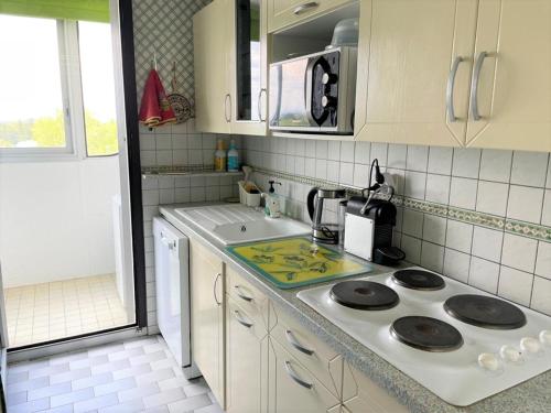 une cuisine avec un évier et une cuisinière dans l'établissement La Grande-Motte: Appart 3 chambres, terrasse, parking, clim, WIFI - FR-1-790-14, à La Grande Motte