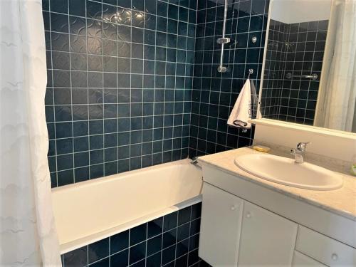 une salle de bain carrelée bleue avec un lavabo et une baignoire dans l'établissement La Grande-Motte: Appart 3 chambres, terrasse, parking, clim, WIFI - FR-1-790-14, à La Grande Motte