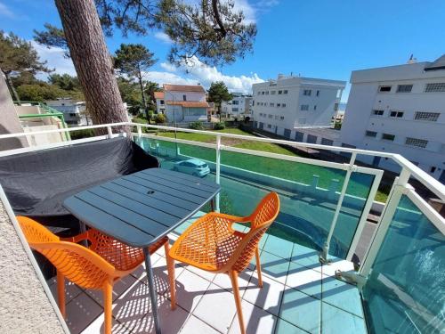 d'un balcon avec une table et des chaises, ainsi que d'une piscine. dans l'établissement Charmant appart rénové à 50m de la plage avec balcon et parking - FR-1-550-78, à Royan