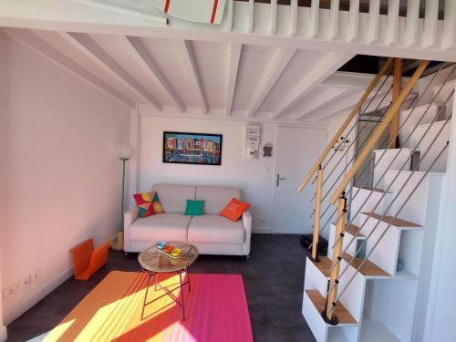 - un salon avec un canapé blanc et des escaliers dans l'établissement Charmant appart rénové à 50m de la plage avec balcon et parking - FR-1-550-78, à Royan