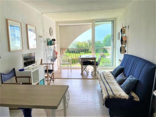 un salon avec un canapé bleu et une table dans l'établissement Appartement Familial 2 Ch. à 50m de la Plage avec Parking, La Grande Motte - FR-1-790-18, à La Grande Motte