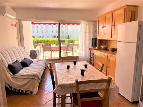 Il dispose d'une cuisine et d'un salon avec une table et un réfrigérateur. dans l'établissement Studio Cabine à La Grande Motte - Plage Proche, Climatisé, Terrasse, Parking - FR-1-790-8, à La Grande Motte