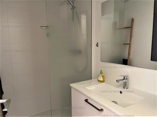 une salle de bain avec une douche avec un lavabo et un miroir dans l'établissement Studio Cabine à La Grande Motte - Plage Proche, Climatisé, Terrasse, Parking - FR-1-790-8, à La Grande Motte