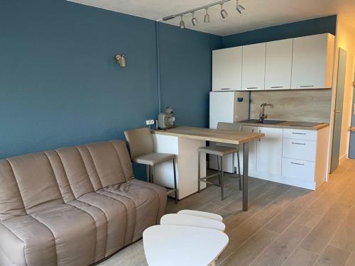 un salon avec un canapé et une table et une cuisine dans l'établissement Studio Rez-de-Jardin Proche Plage avec Parking - La Grande Motte - FR-1-790-27, à La Grande Motte
