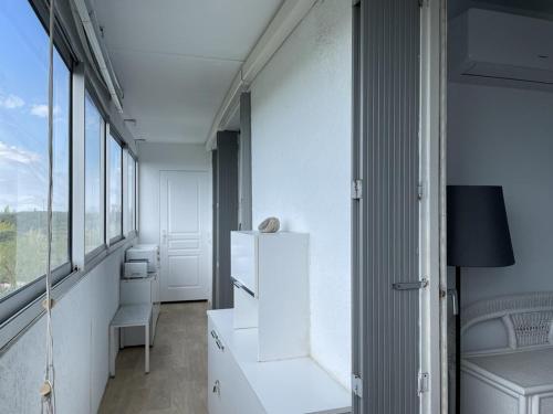 une pièce avec un réfrigérateur blanc et quelques fenêtres dans l'établissement Appartement 5 pers, Clim, Parking, 2 Ch - La Grande Motte - FR-1-790-9, à La Grande Motte