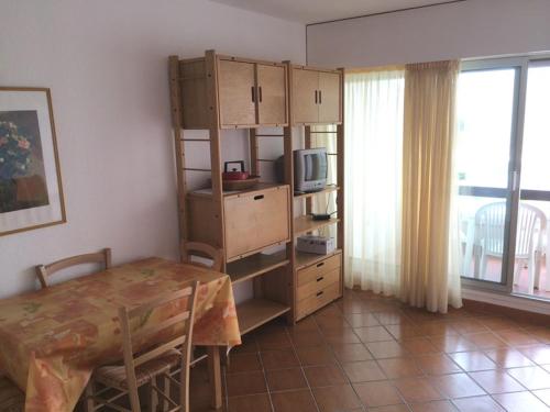 une salle à manger avec une table et une pièce avec un micro-ondes dans l'établissement Studio cabine lumineux 4 pers avec loggia, à 2 pas de la plage et parking privé - La Grande Motte - FR-1-790-10, à La Grande Motte