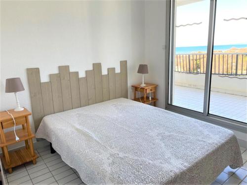 une chambre avec un lit et une grande fenêtre dans l'établissement Appartement 1 chambre en bord de mer, 34m² d’extérieurs, parking privé, La Grande Motte - FR-1-790-22, à La Grande Motte