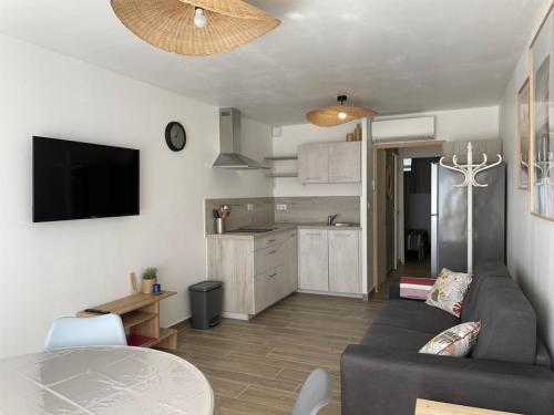 un salon avec un canapé et une table et une cuisine dans l'établissement Appartement rénové à 50m de la plage, climatisé, Parking, 4 couchages, La Grande-Motte - FR-1-790-13, à La Grande Motte