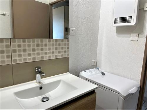 une salle de bain avec un lavabo blanc et un miroir dans l'établissement Appartement 1 chambre en bord de mer, 34m² d’extérieurs, parking privé, La Grande Motte - FR-1-790-22, à La Grande Motte