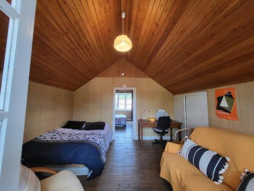 une chambre avec un lit et un canapé dans une pièce dans l'établissement Échappez-vous à deux pas de la plage: Maison bretonne 6 pers. avec jardin et terrasse, St-Brevin - FR-1-364-172, à Saint-Brévin-les-Pins