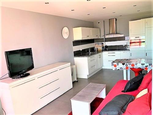 un salon avec un canapé rouge et une télévision dans l'établissement Bel Appartement 1 Chambre à La Grande-Motte avec Loggia et Parking, Proche Plage et Centre - FR-1-790-25, à La Grande Motte