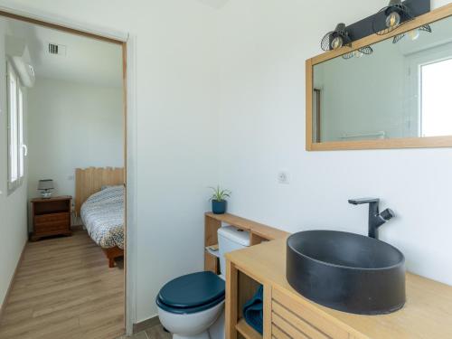 une salle de bain avec un lavabo, des toilettes et un miroir dans l'établissement Maison climatisée à Parentis-en-Born, proche centre et lac, 6 pers, ménage inclus - FR-1-319-560, à Parentis-en-Born