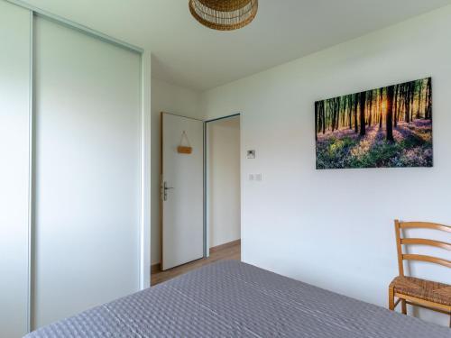 une chambre avec un lit et un tableau au mur dans l'établissement Maison climatisée à Parentis-en-Born, proche centre et lac, 6 pers, ménage inclus - FR-1-319-560, à Parentis-en-Born